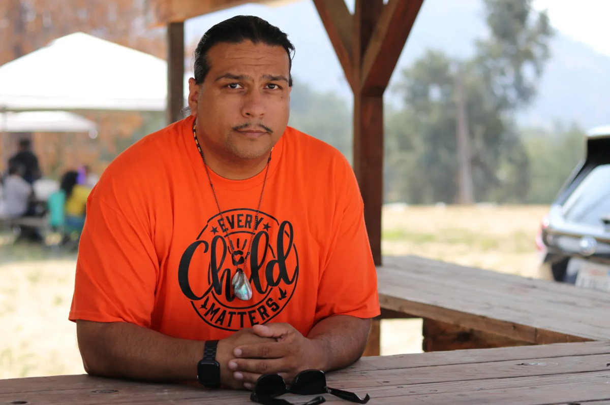 Roman Rain Tree poses for a photo just outside a tribe community event on Sept. 23. Rain Tree, a member of the Dunlap Band of Mono Indians and the Choinumni tribe, has been advocating for Fresno County to acknowledge a federal decision to remove a racist and sexist slur from the name of a Fresno County foothill community.