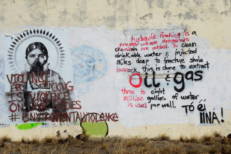 Anti-fracking graffiti on an abandoned house near Bloomfield, New Mexico, near Navajo Nation, expresses opposition to the oil and gas in the area. 