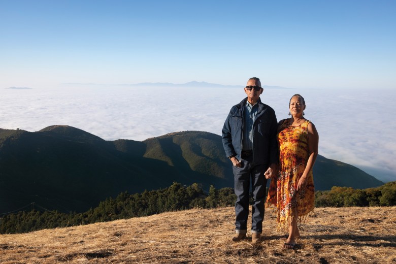 Jacques and Angeletta Powers pose on a hill overlooking their inaccesible property in Crestline, California.