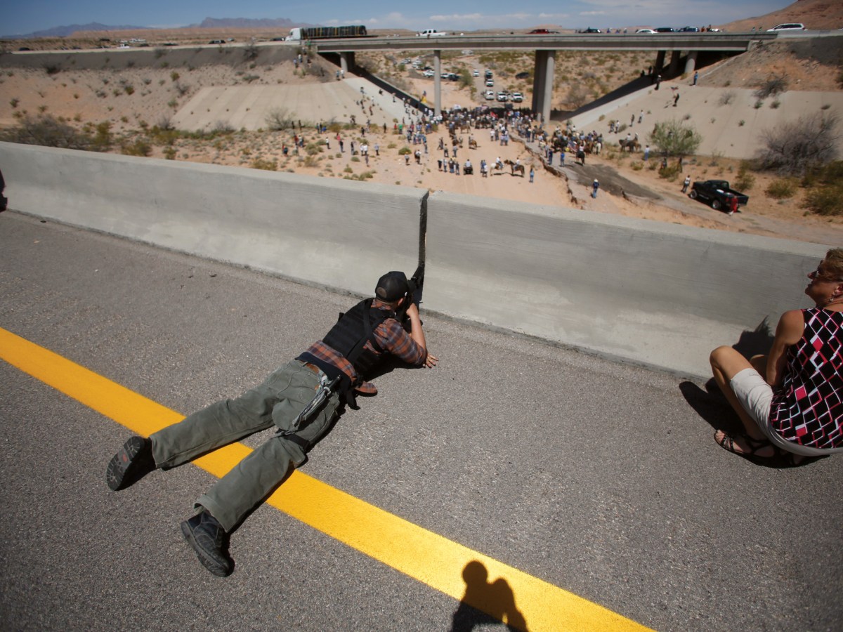 Eric Parker from central Idaho aims his weapon from a bridge as protesters gather by the Bureau of Land Management’s base camp near Bunkerville, Nevada, in April 2014.