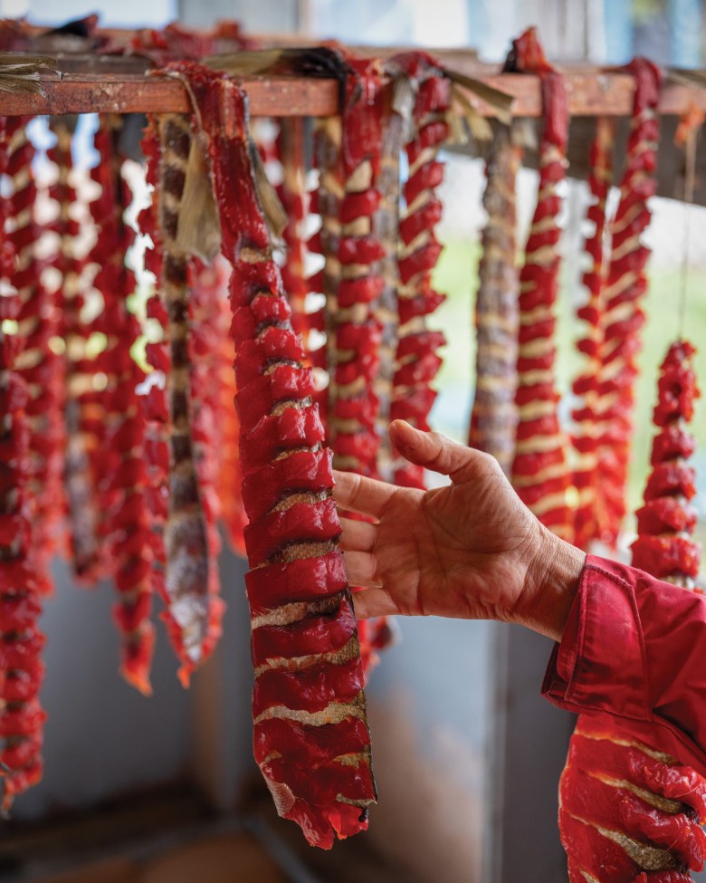 Katie Kangas inspects the recently smoked salmon in her smokehouse in Ruby, Alaska.